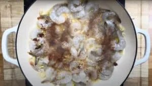 Cooking shrimp with garlic, chili flakes, and spices in a pan for a flavorful seafood dish.